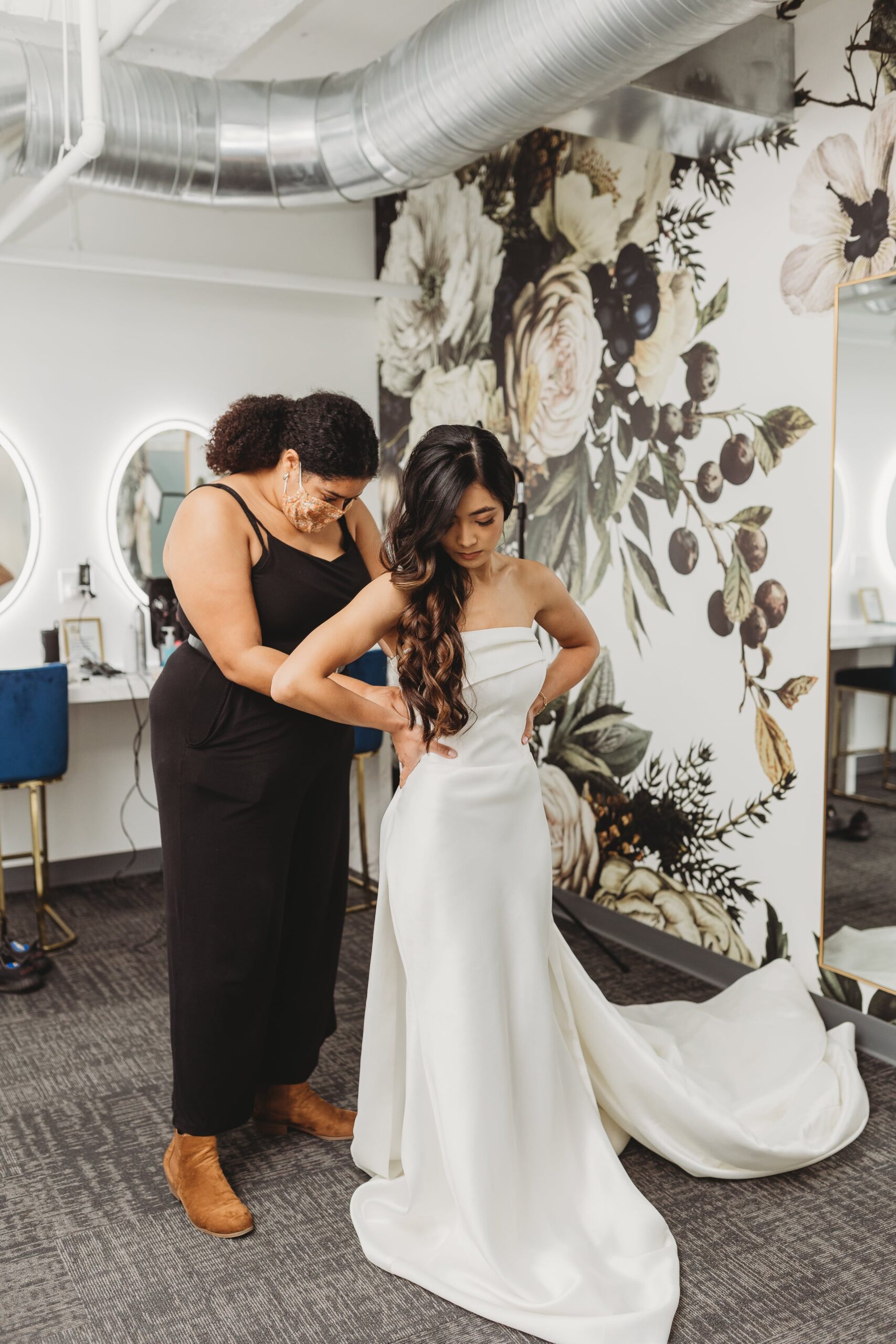 wedding planner helping bride into dress at Outreach Event Space
