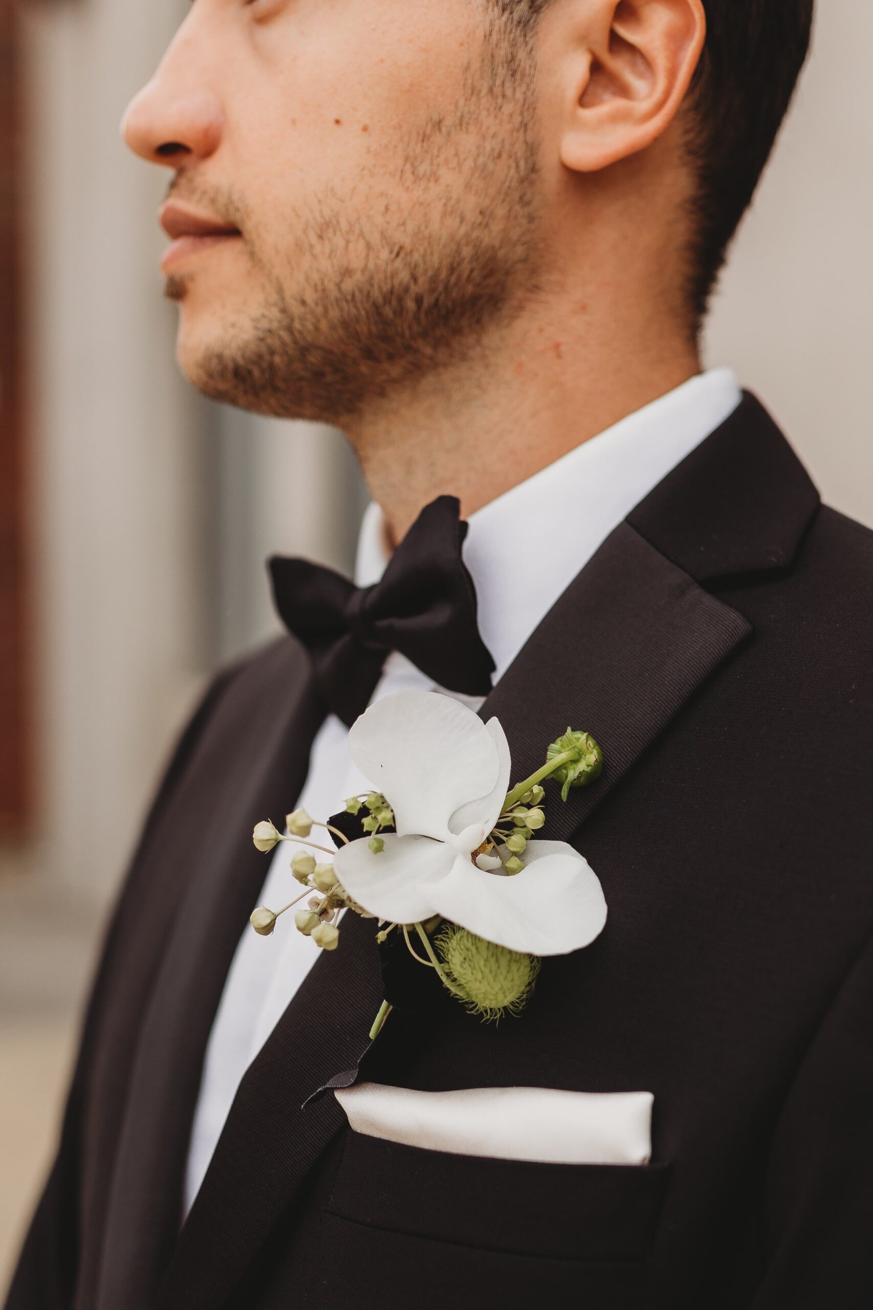 photo of a groom's white and green orchid boutonniere outside of Outreach Event Space