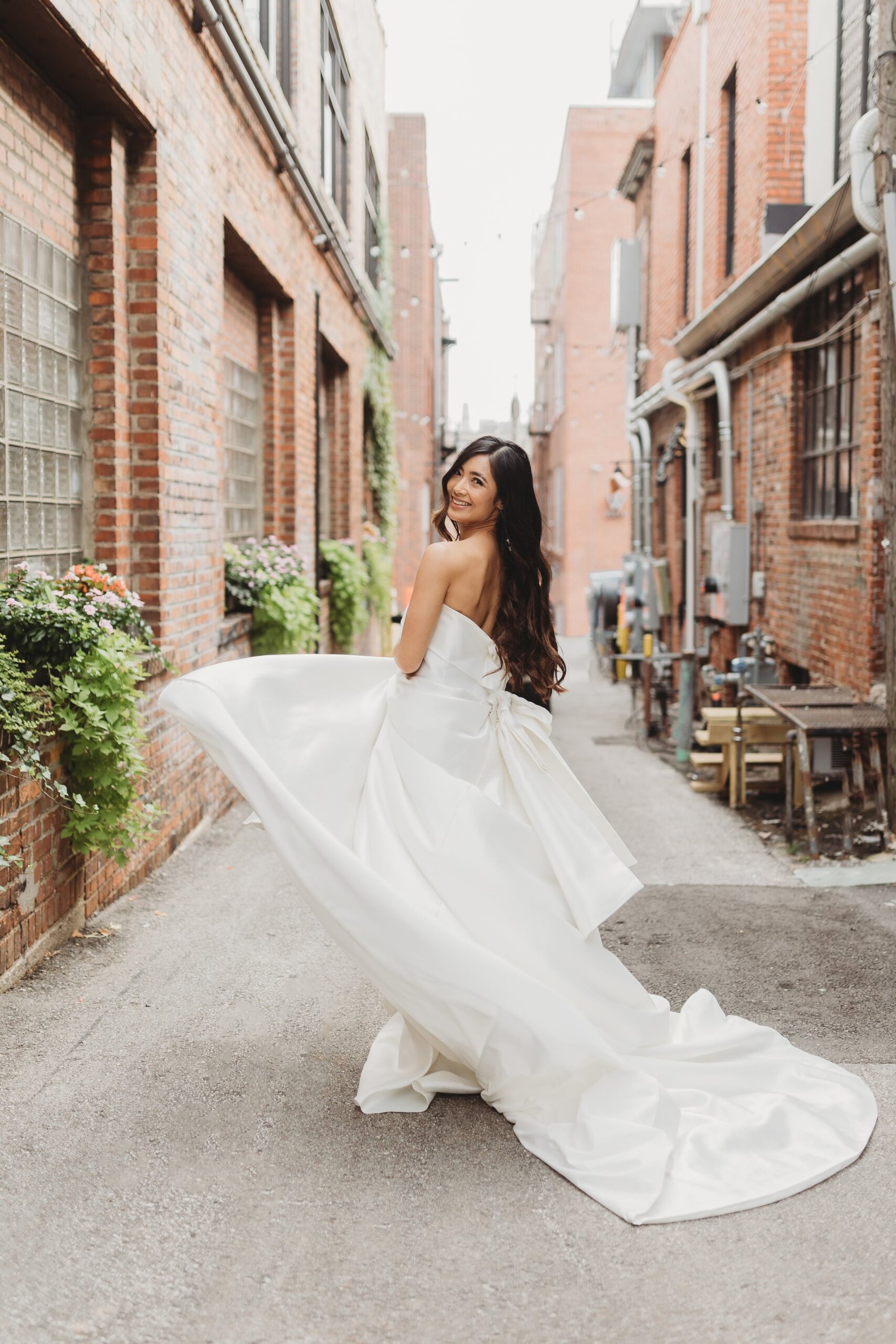 bride twirling in her dress in the alley outside of Outreach Event Space