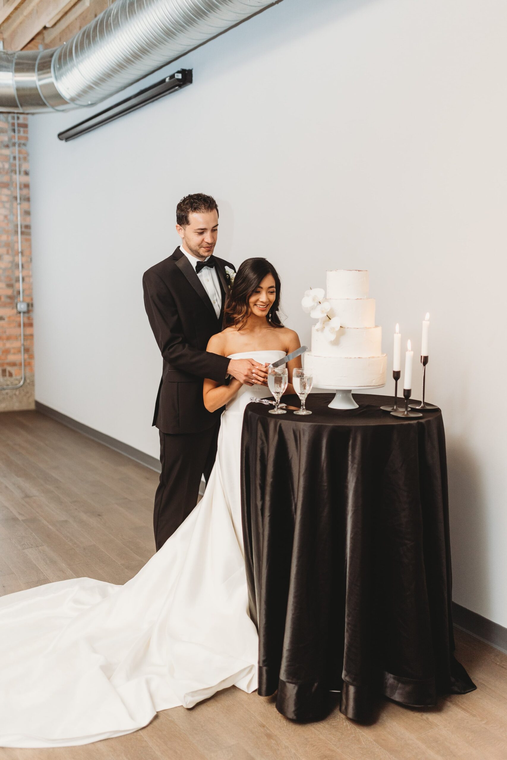 bride and groom cutting the cake at their Outreach Event Space wedding