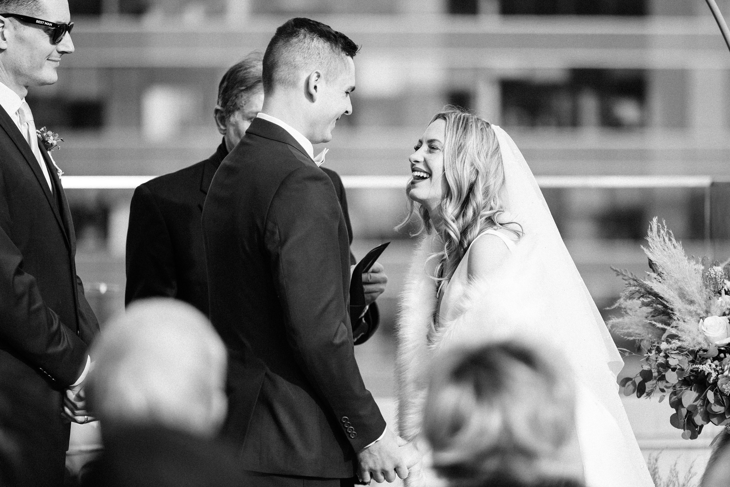 Bride and groom smiling during their wedding ceremony on the Starlight Terrace at Hotel Kansas City