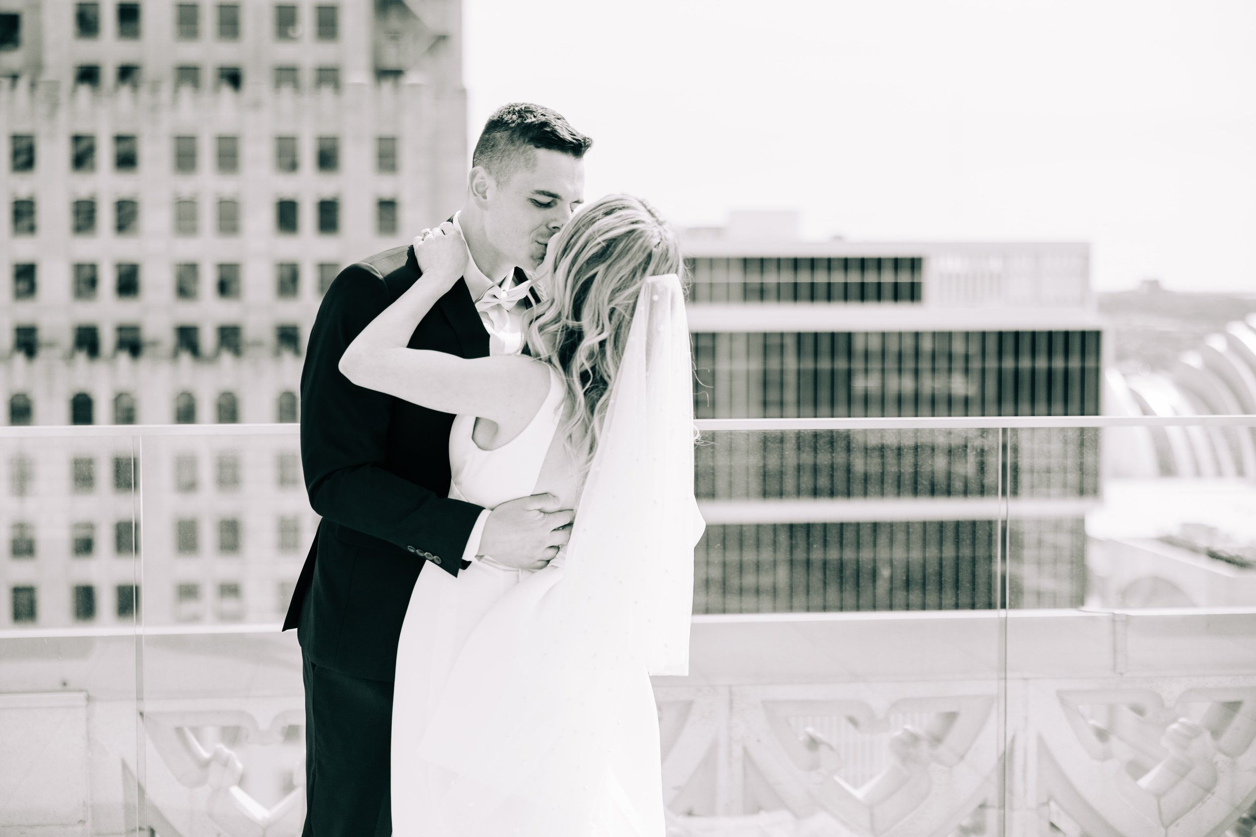 Black and white image of  bride and groom kissing on the Starlight Terrace at Hotel Kansas City