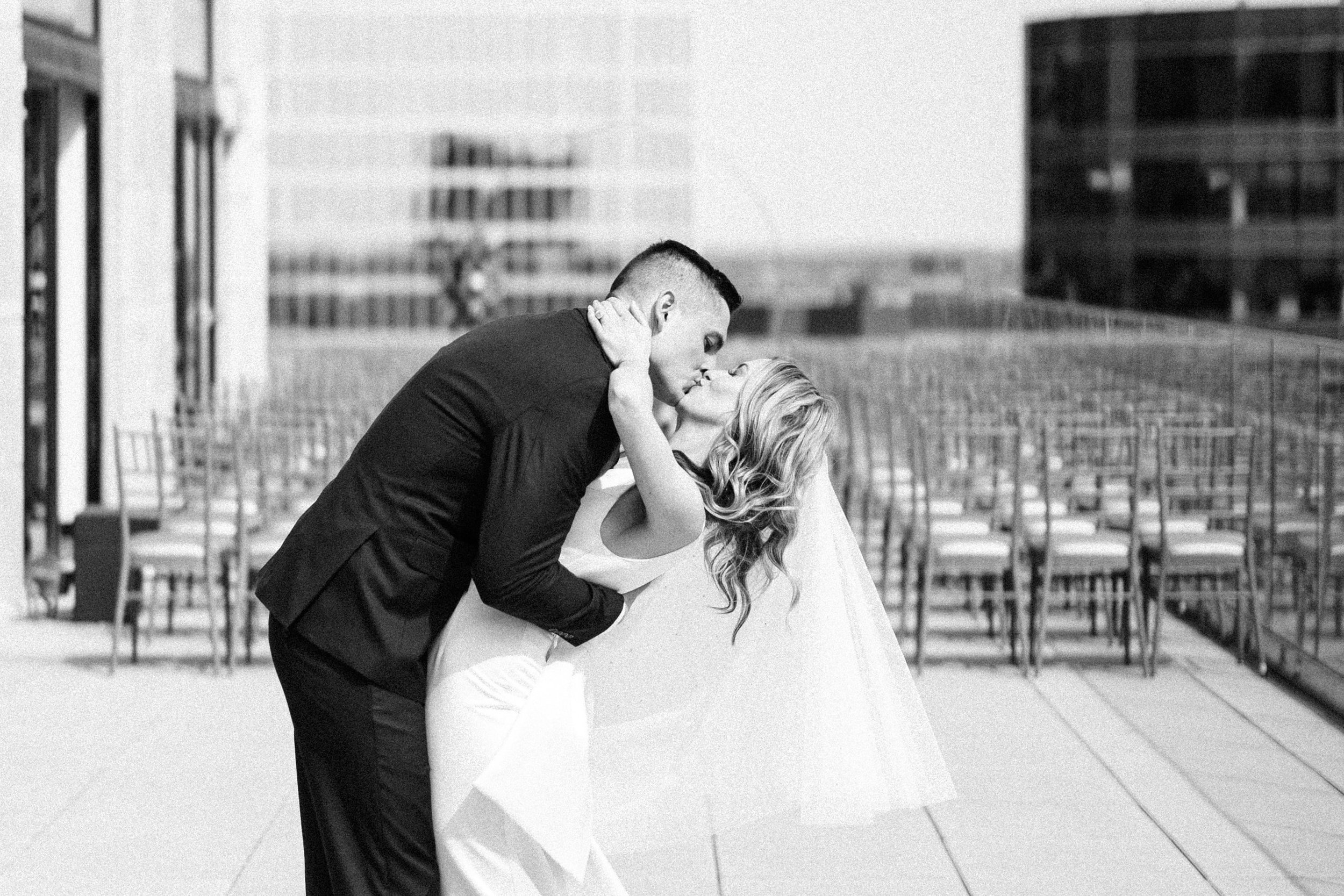 Groom dipping her bride for a kiss on the Starlight Terrace at Hotel Kansas City