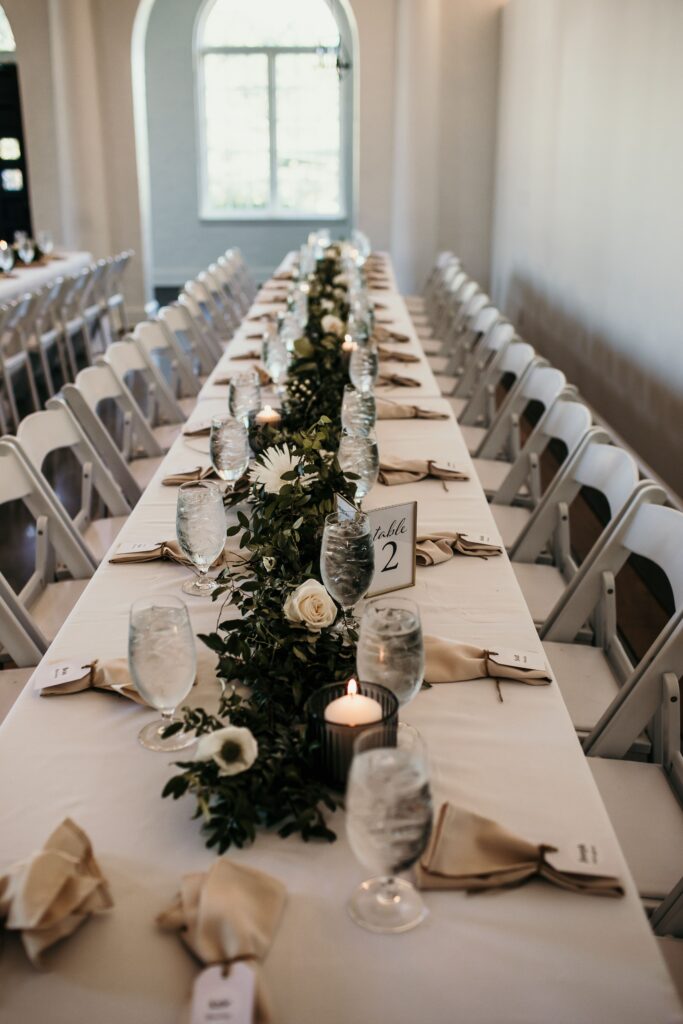 Wedding reception table with greenery and white flowers at La Villa in Kansas City