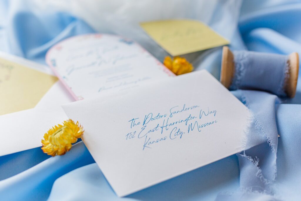 pink, blue, and yellow wedding invitation suite at 1890 event space