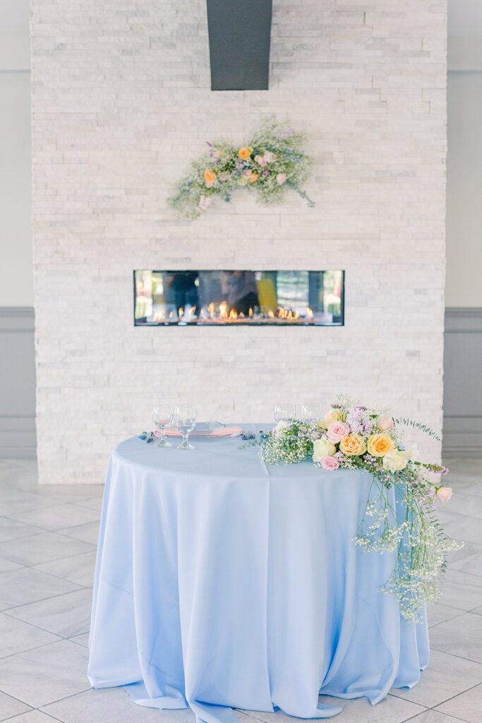 colorful, pastel sweetheart table in front of the fireplace at 1890 event space