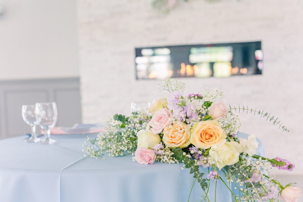 sweetheart table floral arrangement with baby's breath, roses, and eucalyptus at 1890 event space