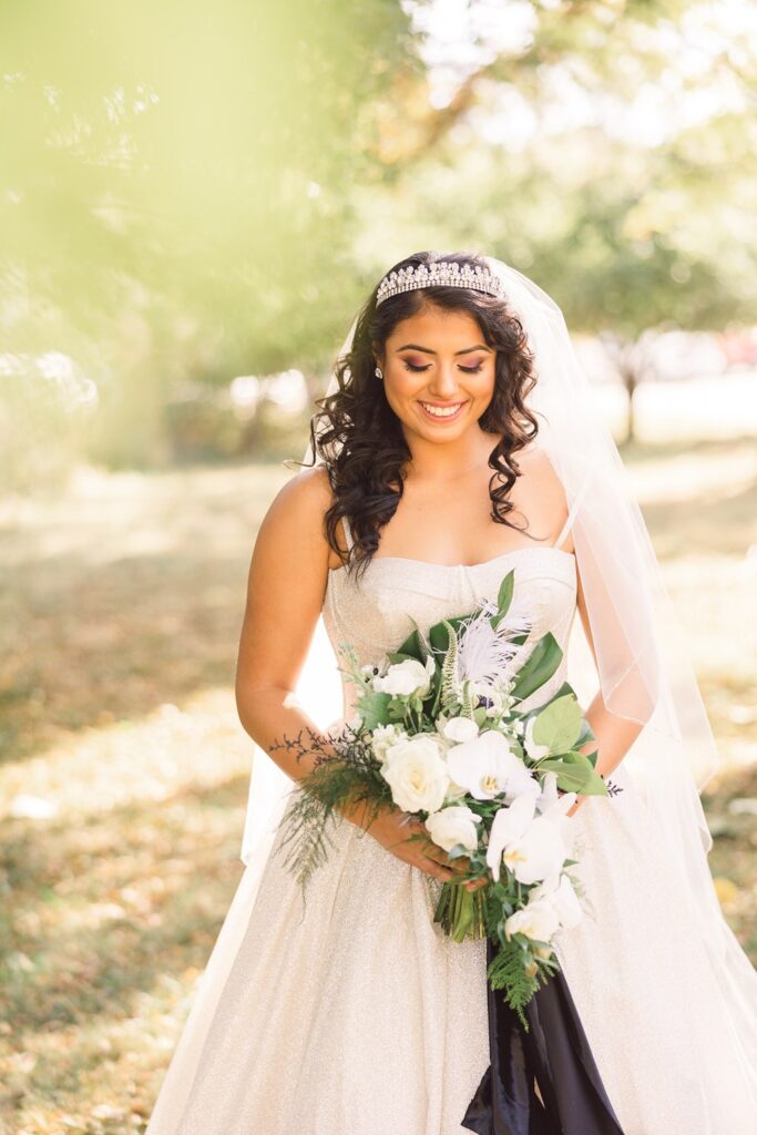 bride in sparkly gown and tiara with white and green bridal bouquet