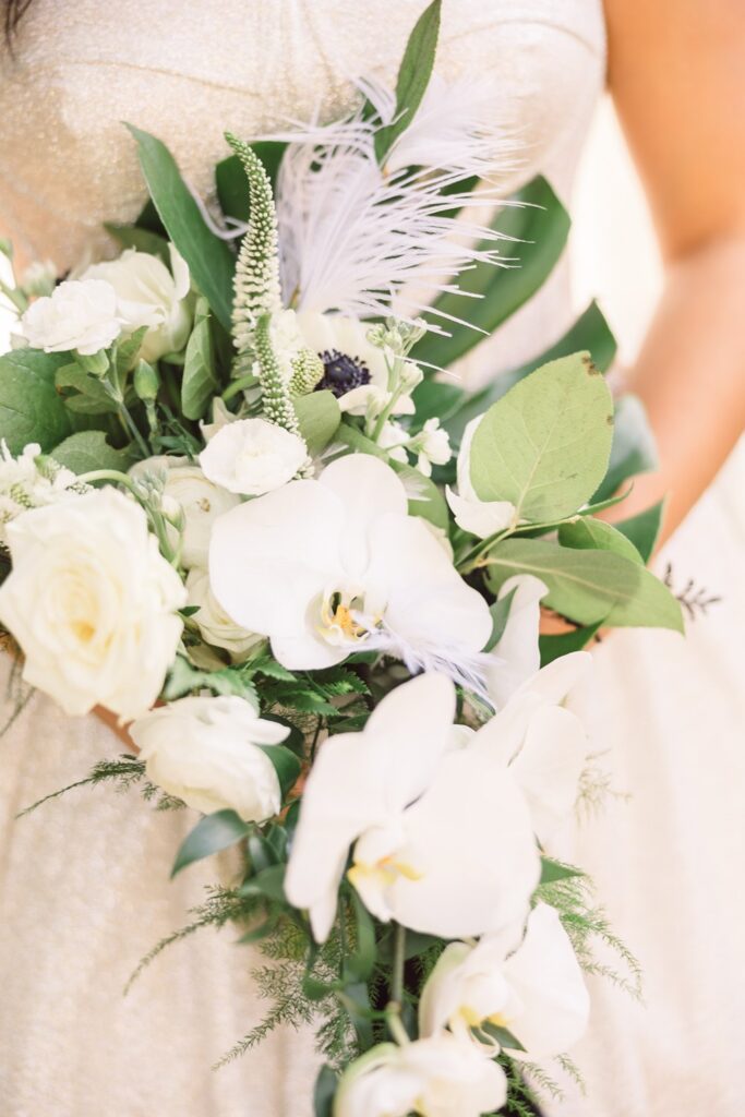 white and green bridal bouquet with orchids, roses, anemone, and monsterra leaf
