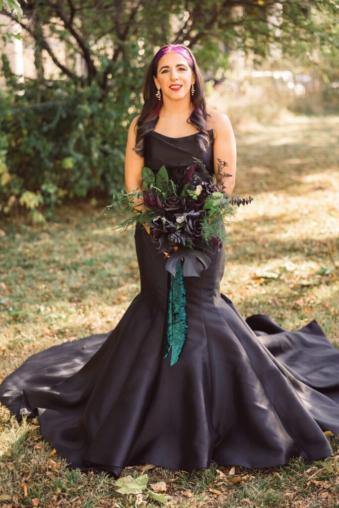 bride in black wedding dress holding black bouquet