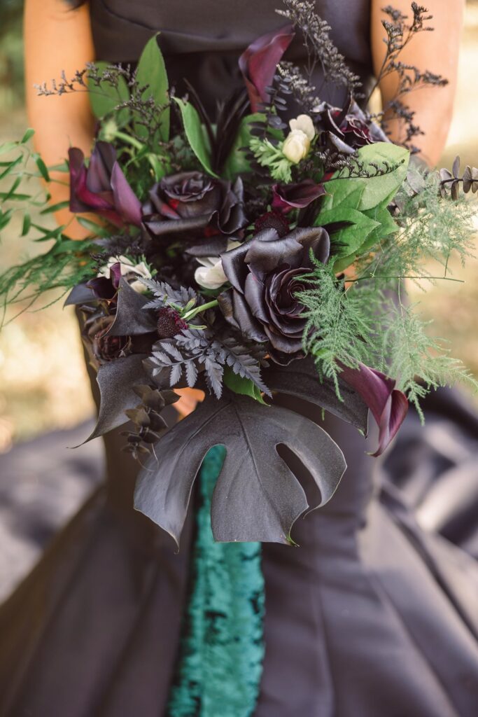 black bridal bouquet with roses and lily of the valley, tied with green ribbon