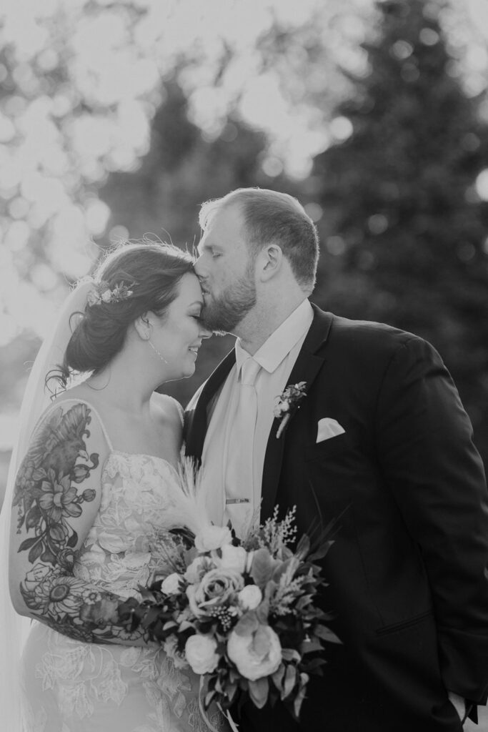 groom kisses bride's forehead at Thompson Barn wedding