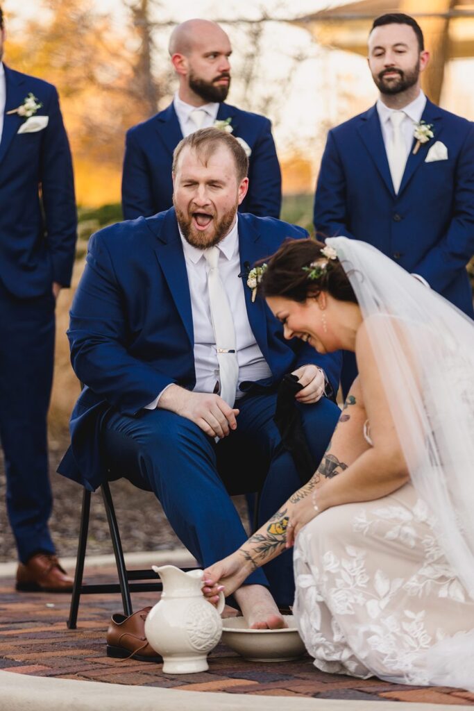 groom's reaction to cold water during foot washing ceremony at Thompson Barn wedding