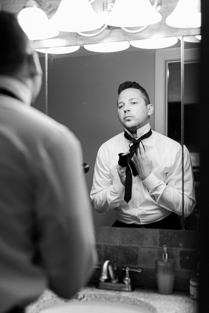 groom putting on tie at 28 Event Space Kansas City Room