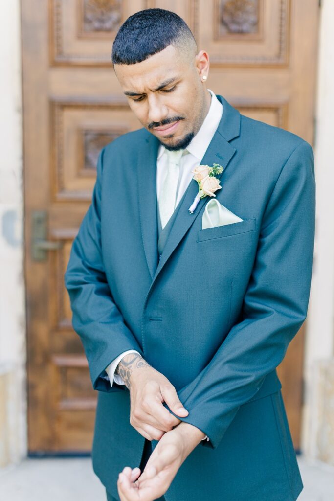 groom in front of the iconic door at Unity Village