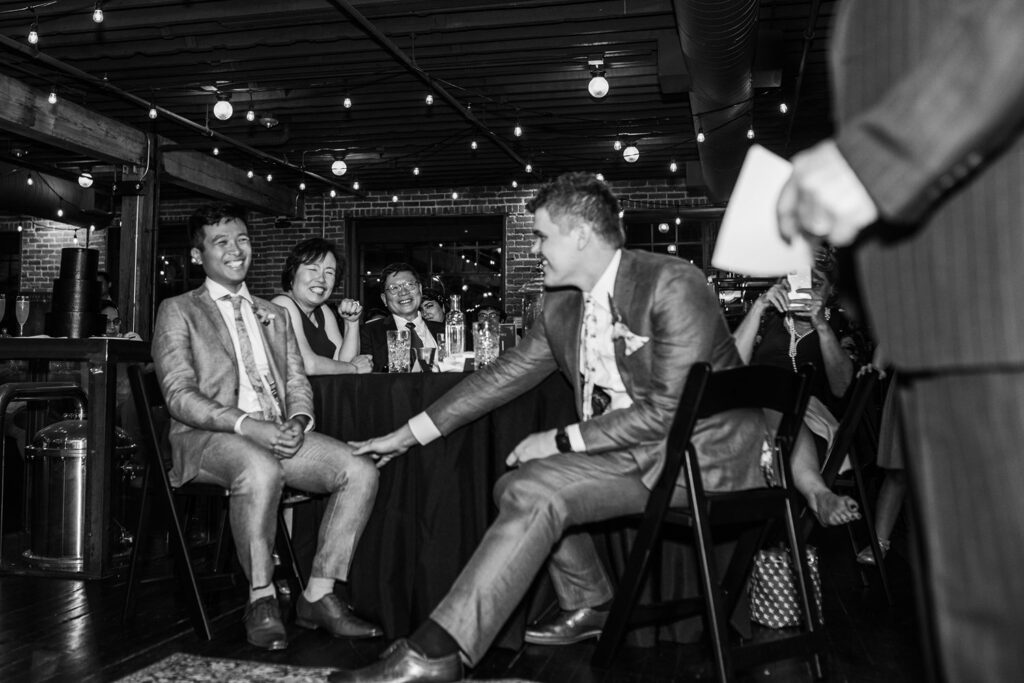 grooms laughing at industrial wedding reception