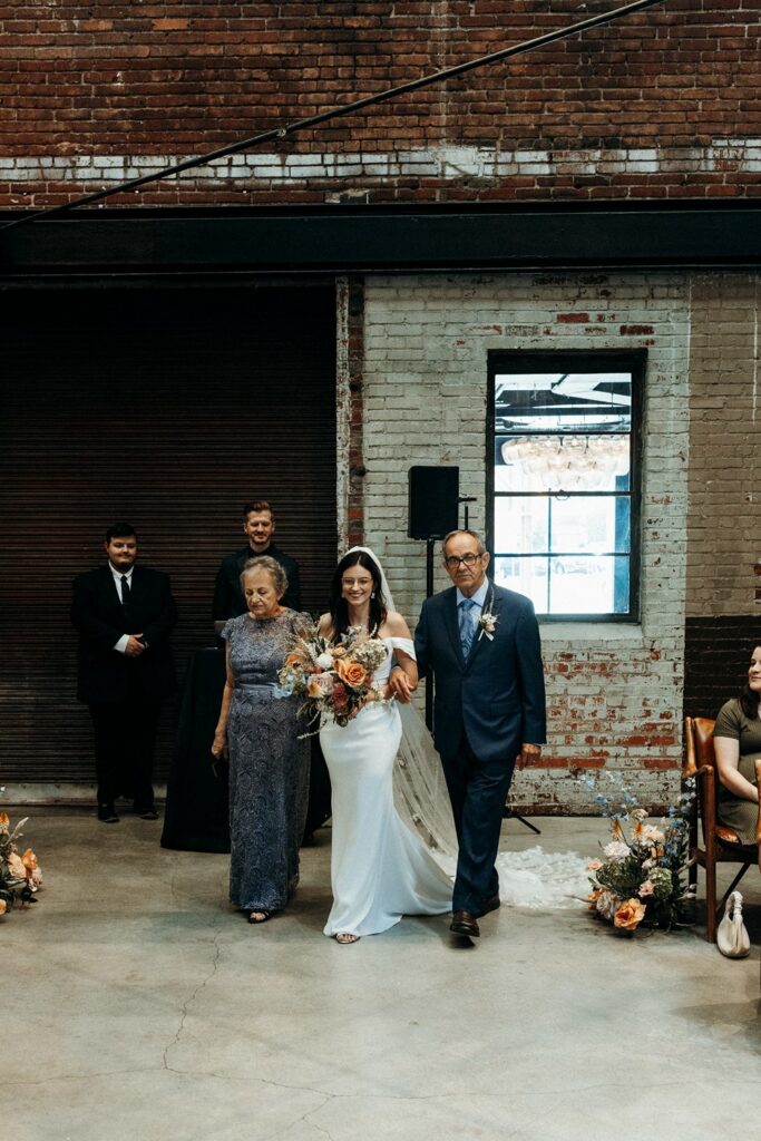 bride walking down the aisle at wedding ceremony at Crossroads Hotel, atrium