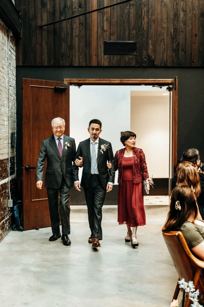 groom walking down the aisle at wedding ceremony at Crossroads Hotel, atrium