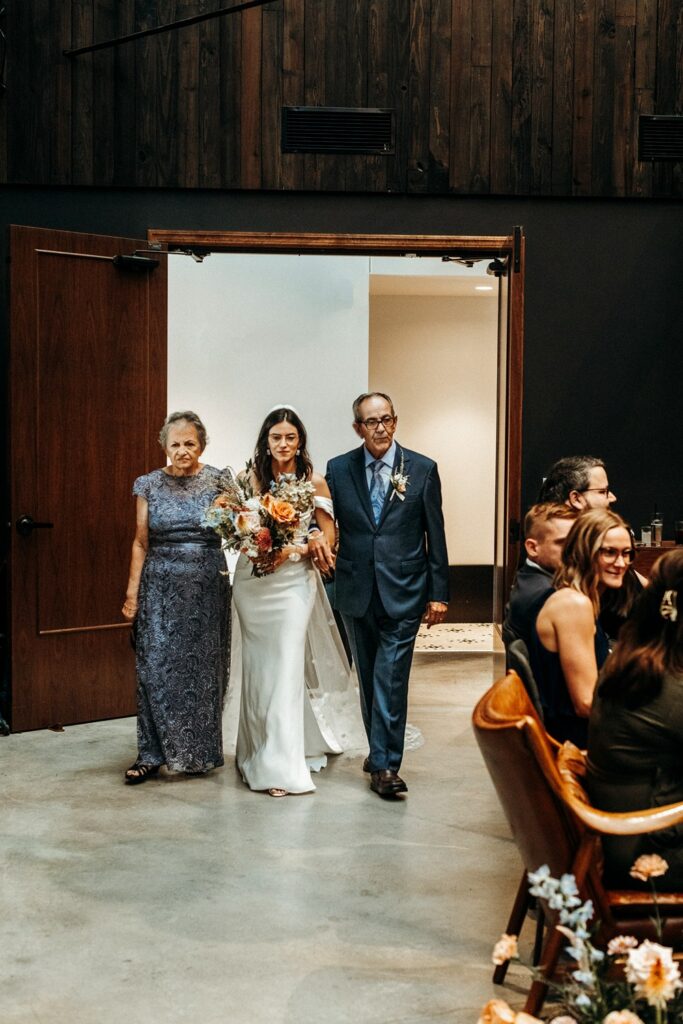 bride walking down the aisle at wedding ceremony at Crossroads Hotel, atrium