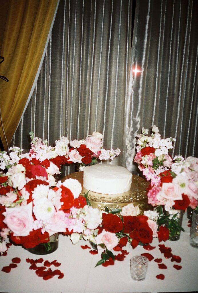 pin and red floral arch around cake