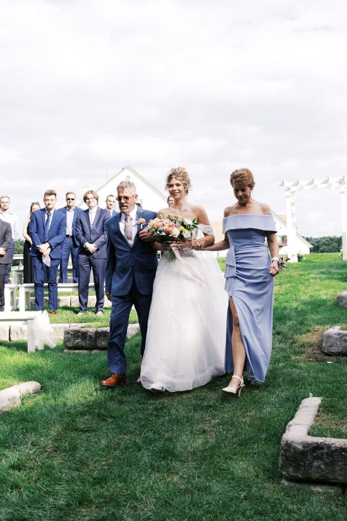 bride walking down the aisle at countryside chalet wedding ceremony