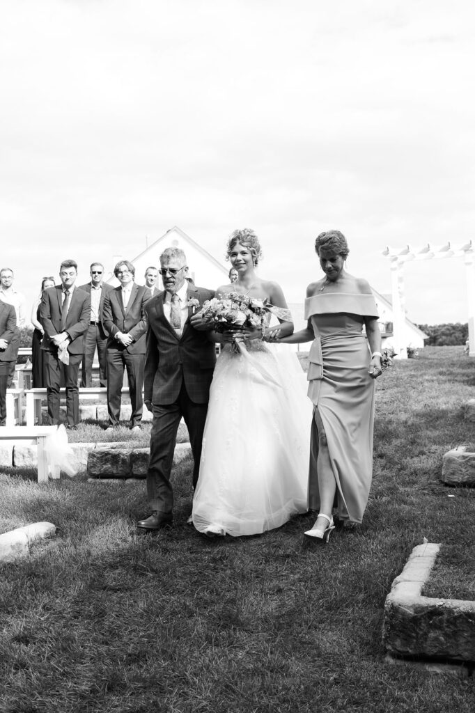 bride walking down the aisle at countryside chalet wedding ceremony