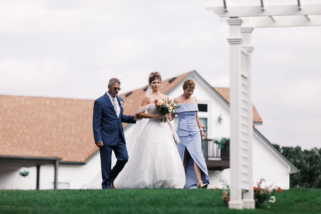 bride walking down the aisle at countryside chalet wedding ceremony