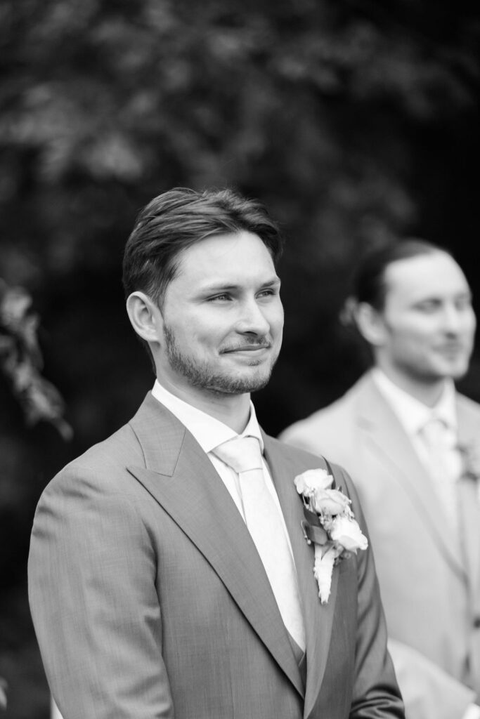groom watching the bride walk down the aisle at countryside chalet wedding ceremony