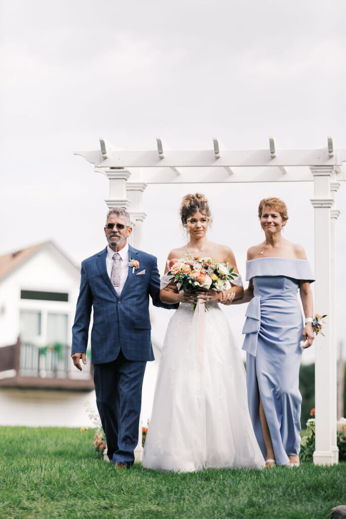 bride walking down the aisle at countryside chalet wedding ceremony