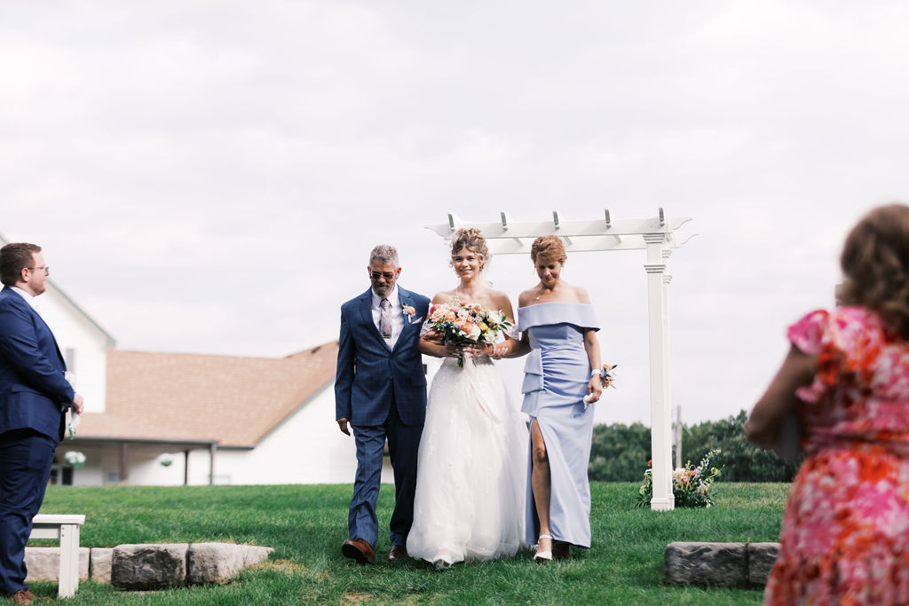 bride walking down the aisle at countryside chalet wedding ceremony