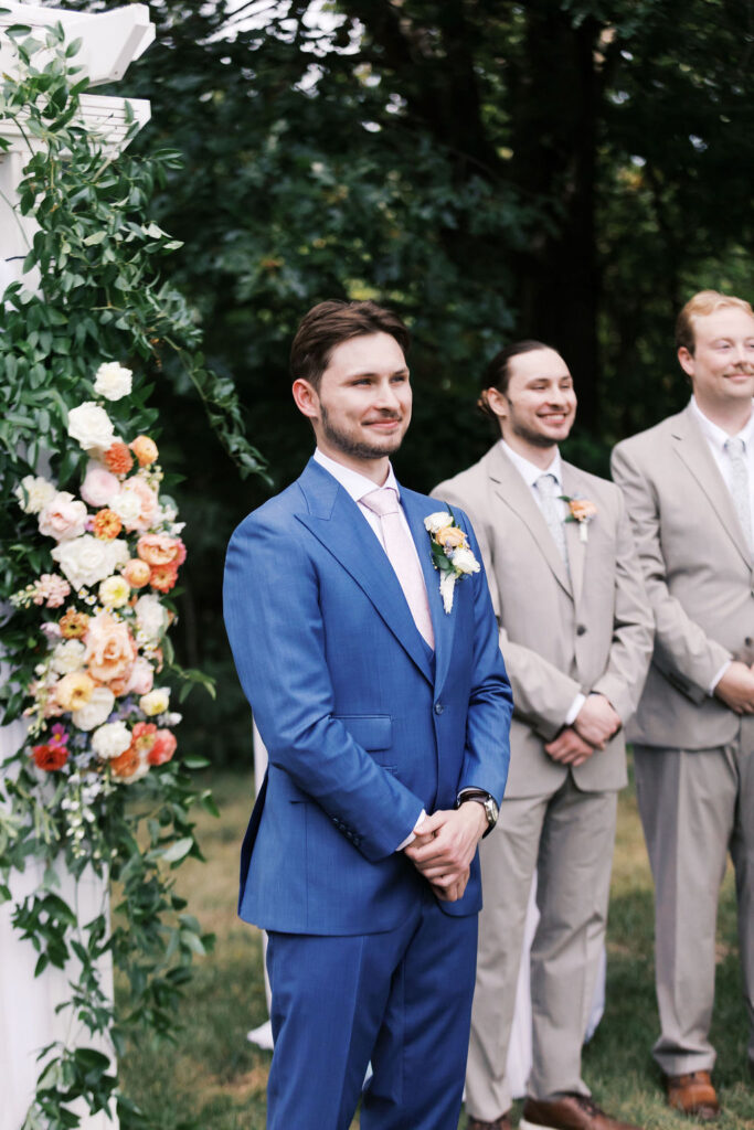 groom watching the bride walk down the aisle at countryside chalet wedding ceremony