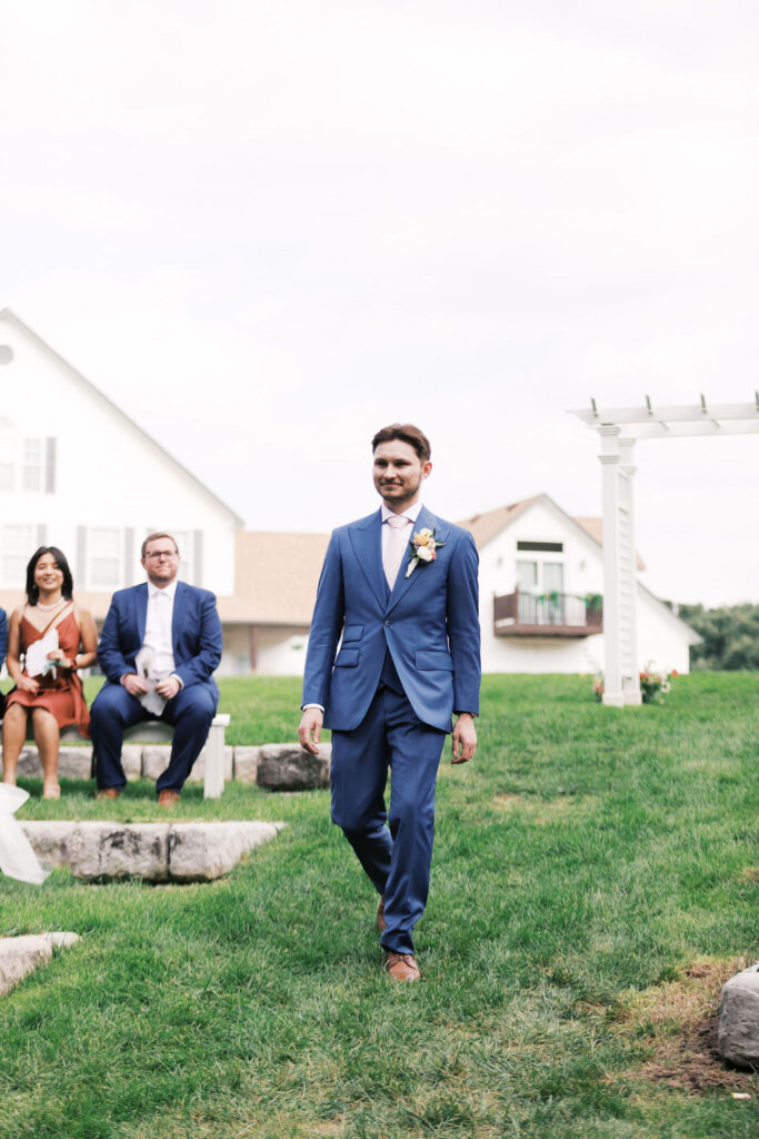 groom walking down the aisle at countryside chalet wedding ceremony