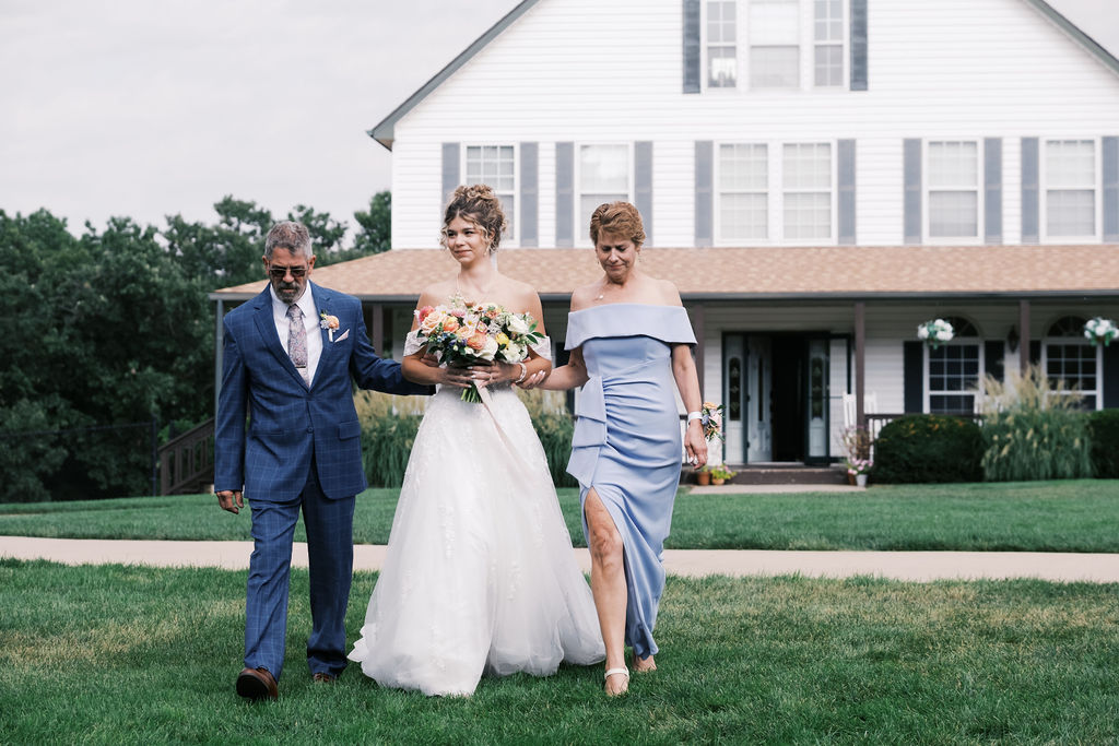 bride walking down the aisle at countryside chalet wedding ceremony