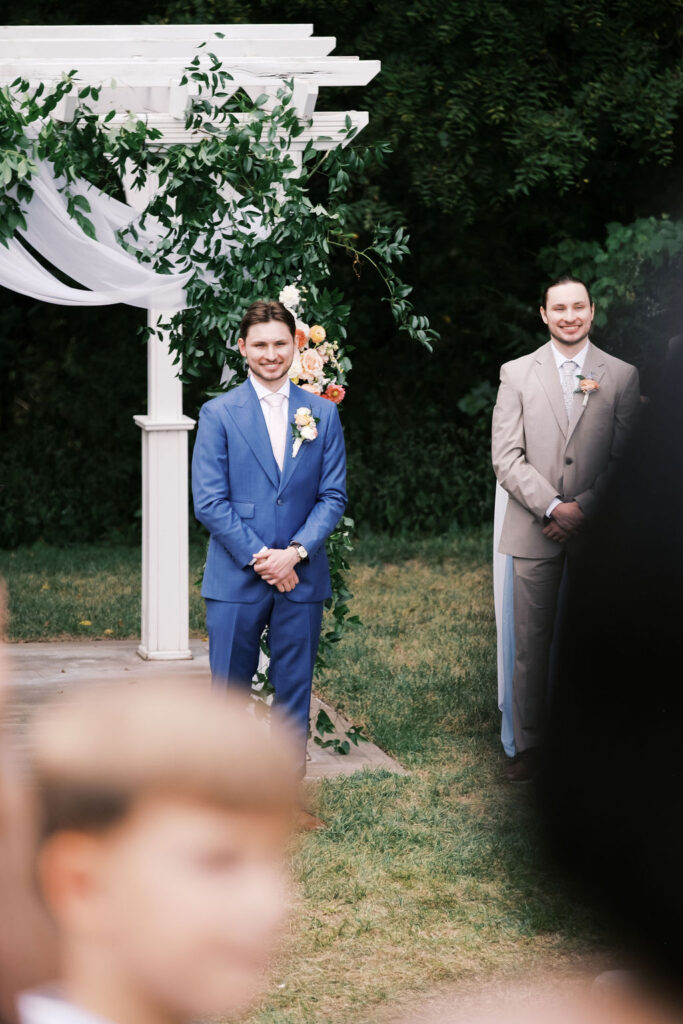 groom watching the bride walk down the aisle at countryside chalet wedding ceremony