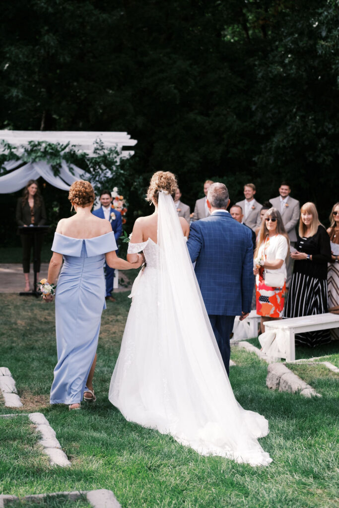 bride walking down the aisle at countryside chalet wedding ceremony