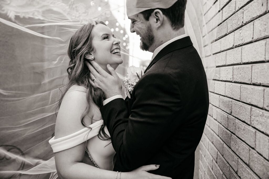 bride and groom smiling at each other in the alley outside of Mission Theatre